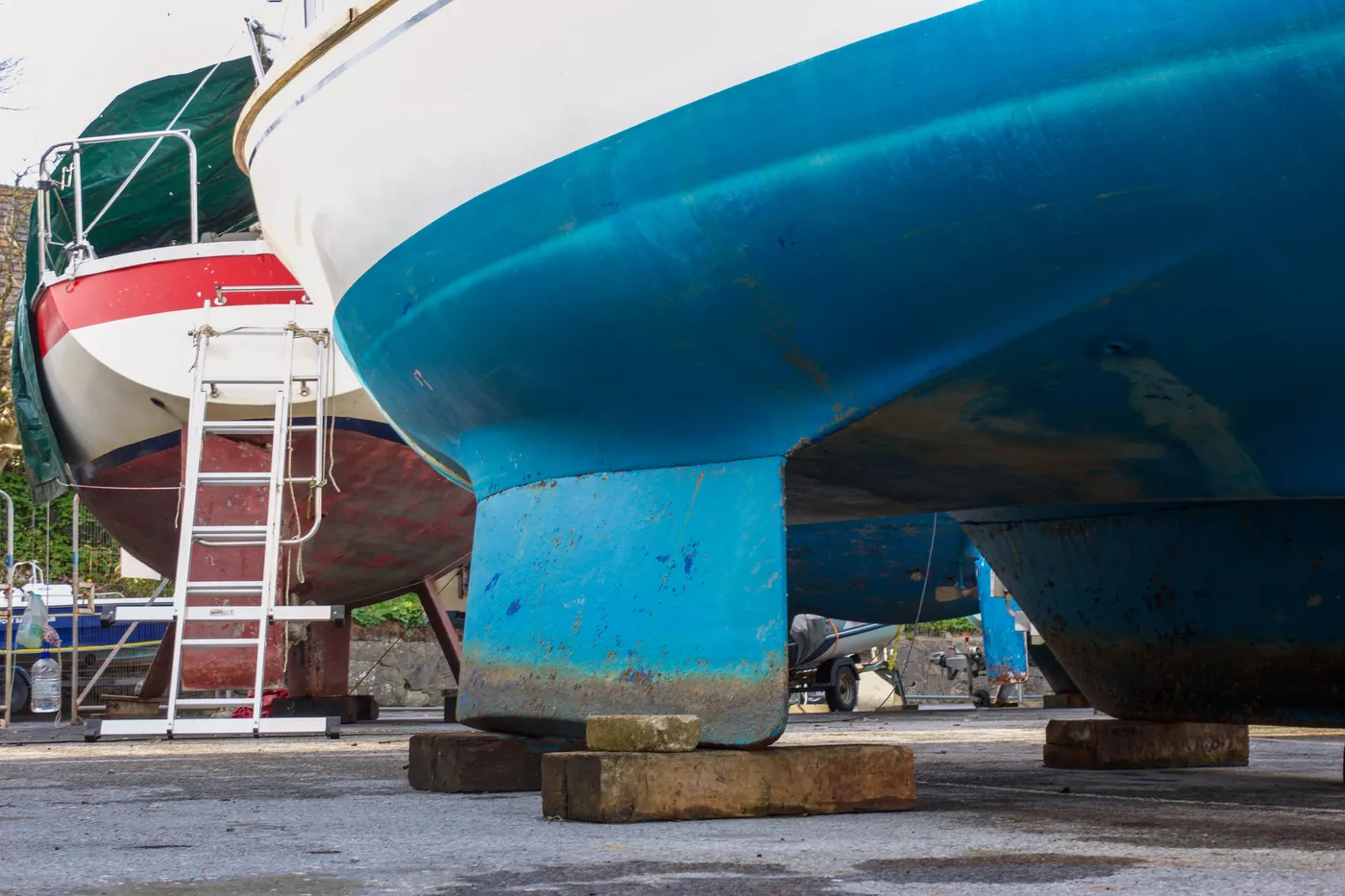 A sailing yacht hauled out on dry-dock stands for an out-of-water hull inspection