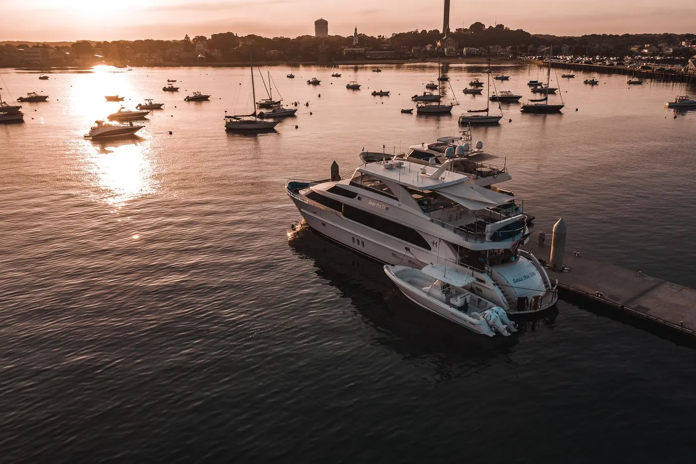 A luxury motor yacht moored in a Narragansett Bay harbor at sunset